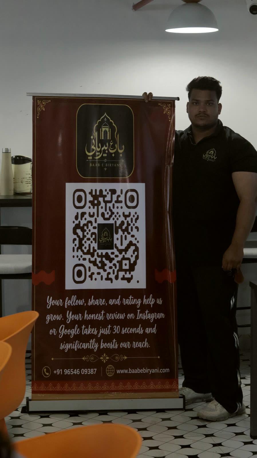 Baab E Biryani crew beside the brand banner at an event