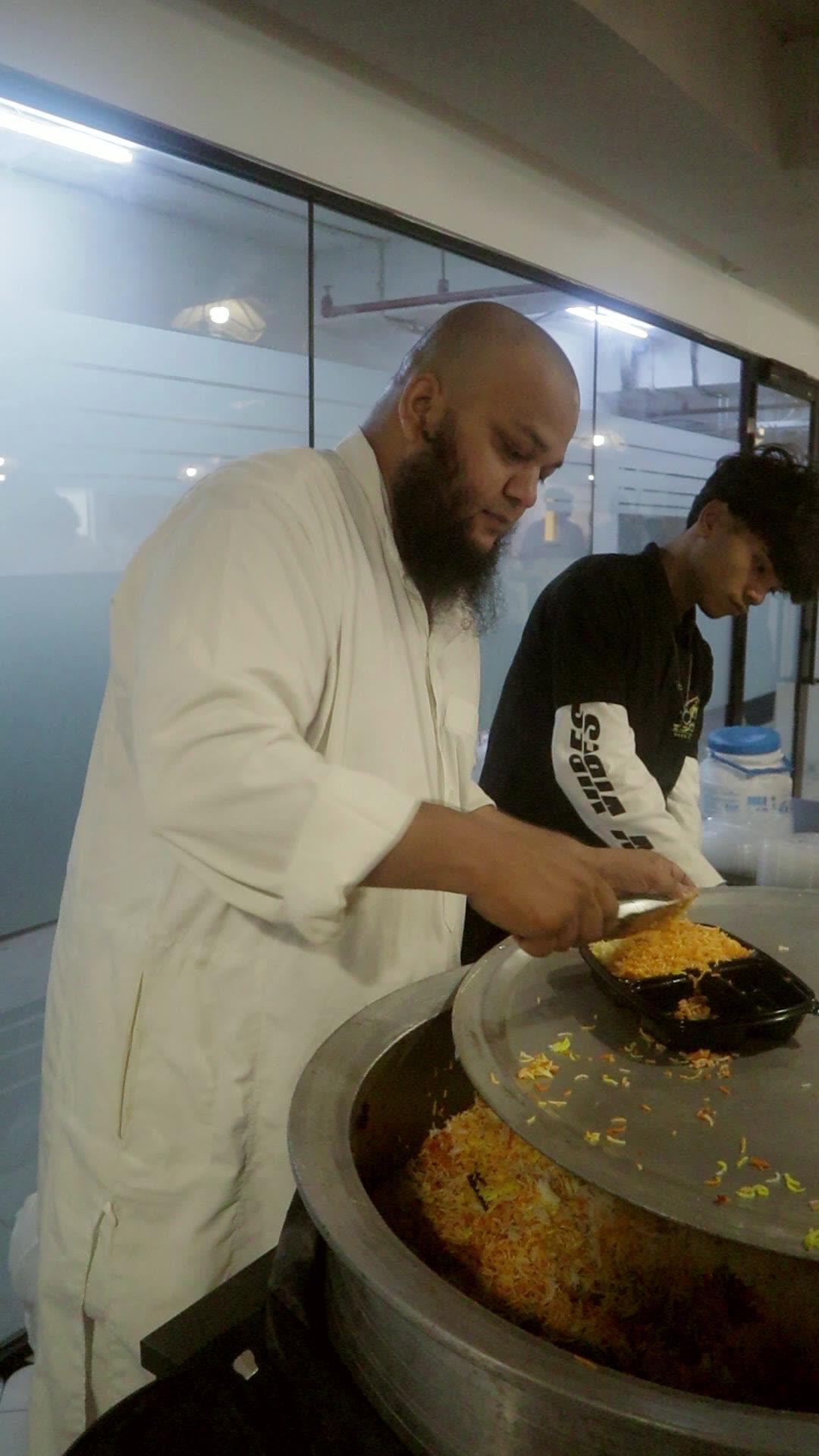 Our founder serving biryani from the handi into meal boxes at an office event