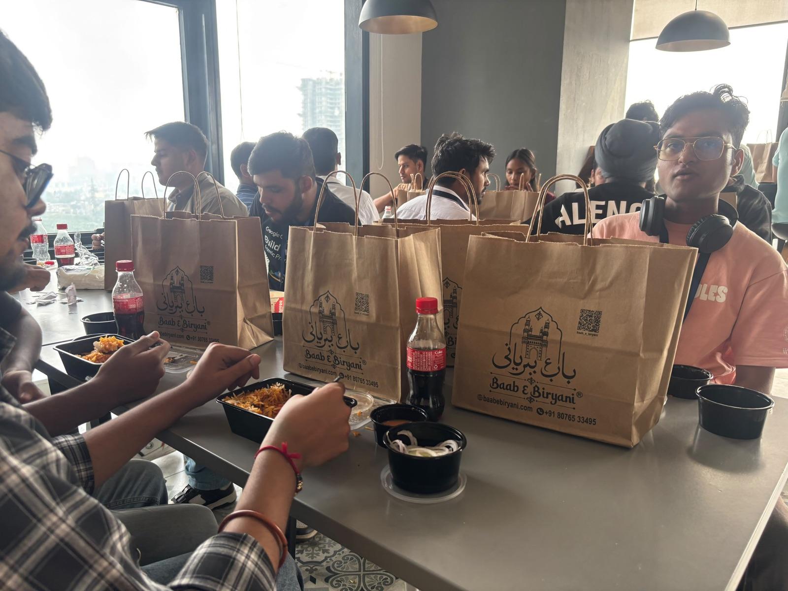 Developers at a GDG community event at Paytm eating Baab E Biryani from branded bags