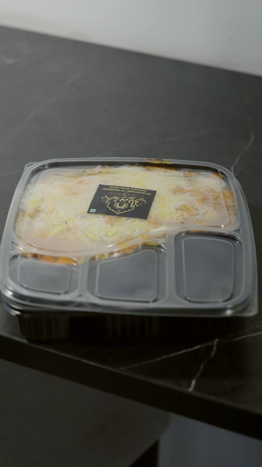 Sealed biryani meal boxes with the Baab E Biryani label
