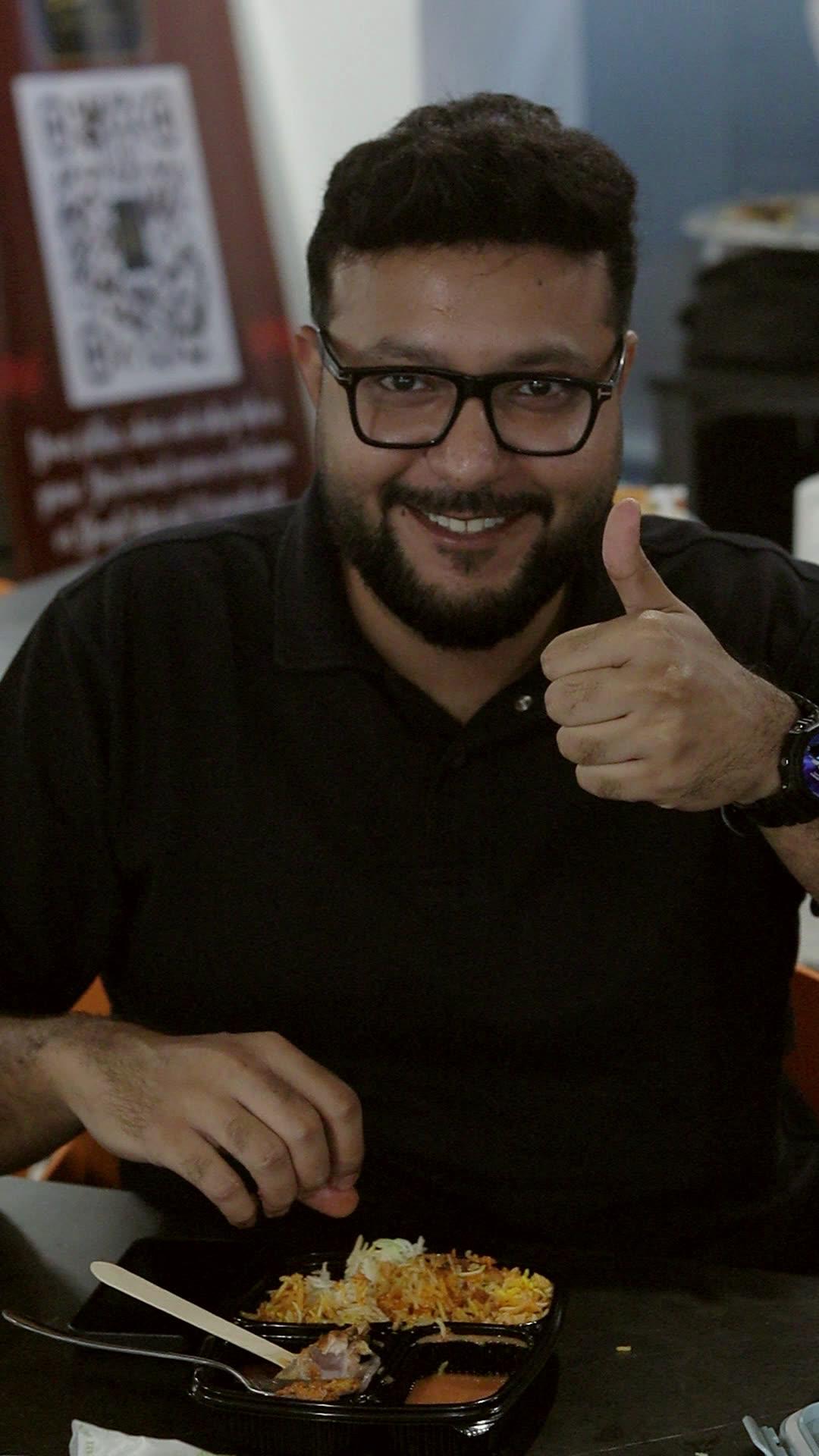 Guest giving a thumbs up over his biryani